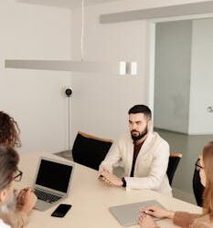 A diverse group engaged in a business meeting in a modern office setting.